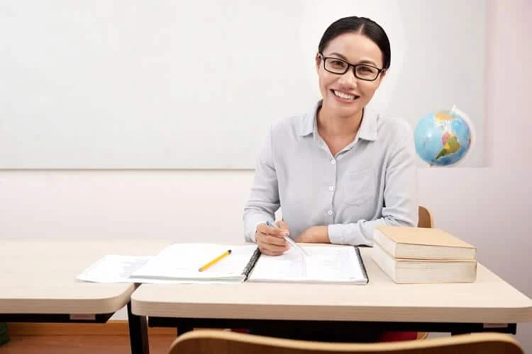 Maestra en su escritorio solicitando un préstamo vía nómina para maestros de la Secretaría de Educación